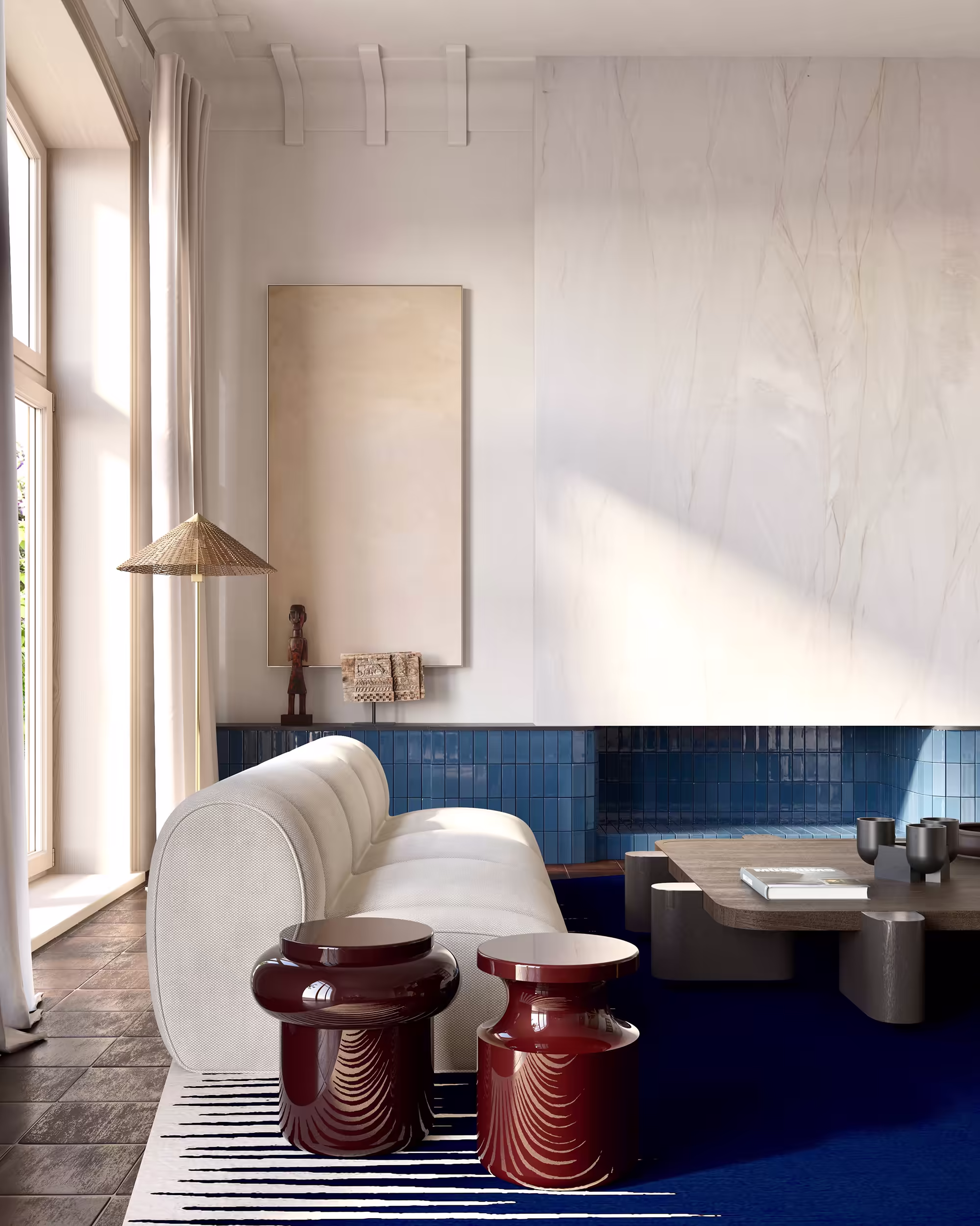 Contemporary living room featuring a rounded white sofa by Popus editions, Invisible Collection against a blue tile fireplace. Two glossy burgundy sculptural side tables by Delcourt Collection add contrast atop a graphic blue-and-white rug by Atelier Fevrier. Neutral artwork and minimal vintage accessories? sculpture by Joan Miro and leather De Sede vintage lounge chair complete the scene.