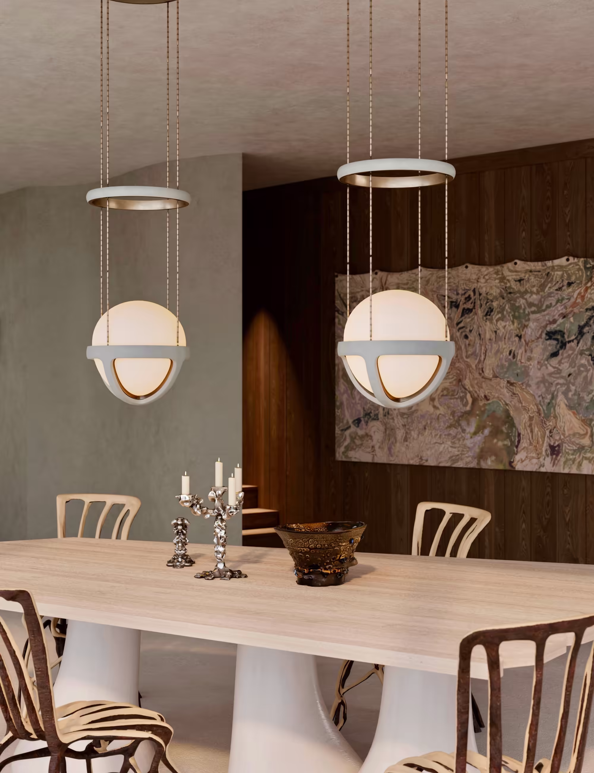 Close-up of the dining area with sculptural fiberglass-based table, Fullgrown tree chairs, and Apparatus pendant lights, set against a dark wooden wall and abstract artwork.
