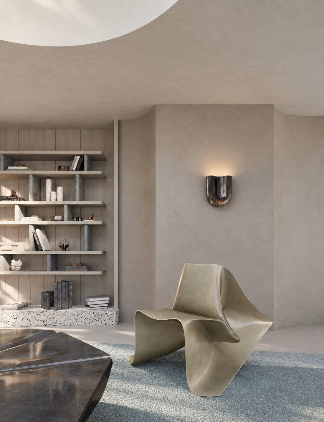 Detail view of the living area showing Fold Chair in raw fiberglass, Onda ceramic sconce, and shelving built into sculpted walls.